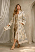 matching clutch bag and wearing nude high-heeled sandals in a rustic, 